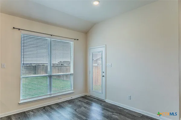 an empty room with wooden floor and a window