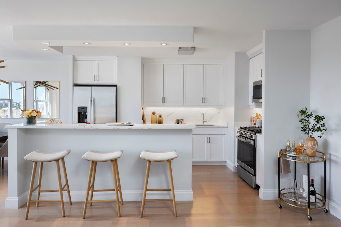 a kitchen with cabinets and chairs