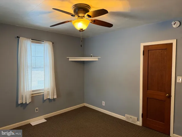 an empty room with windows and painted walls