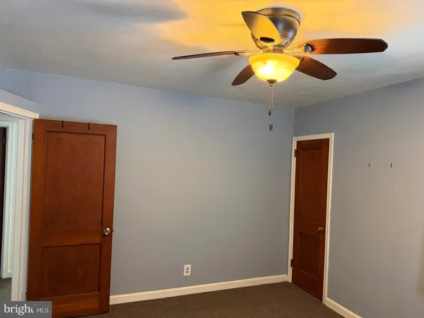 an empty room with closet and a chandelier fan