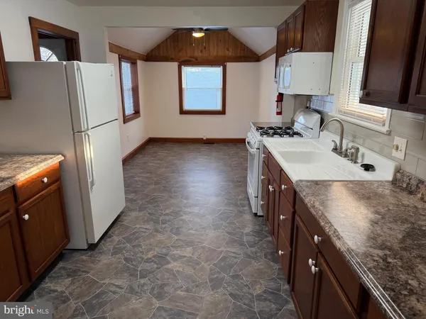 a white refrigerator freezer and a stove sitting inside of a kitchen