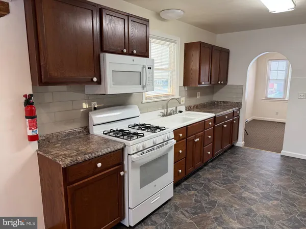 a kitchen with stainless steel appliances granite countertop a refrigerator a stove and a sink