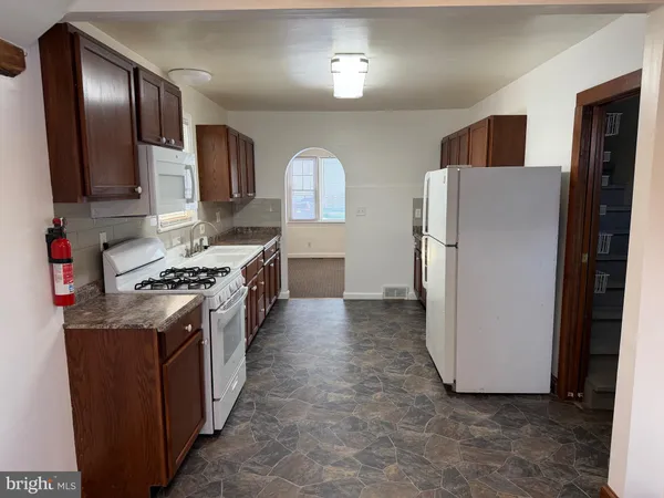 a kitchen with sink a stove and cabinets