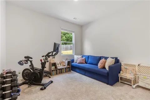 a living room with furniture a gym equipment and a large window