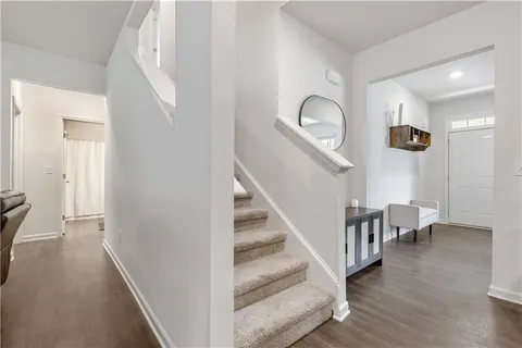 a view of a hallway with wooden floor and entryway