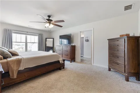 a spacious bedroom with a bed and a chandelier