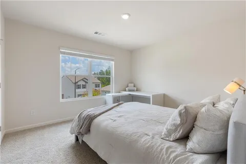 a bedroom with a bed and painting on the wall