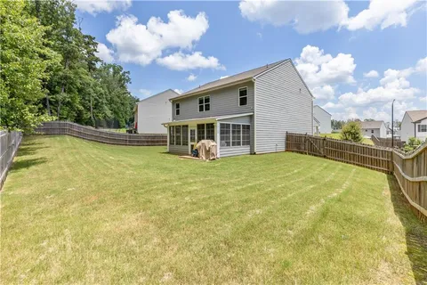 a view of a house with pool and a yard