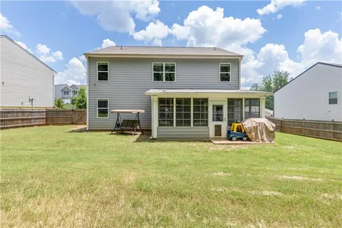 a view of a house with backyard and porch