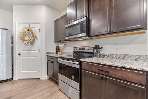 a kitchen with stainless steel appliances granite countertop a stove microwave and cabinets