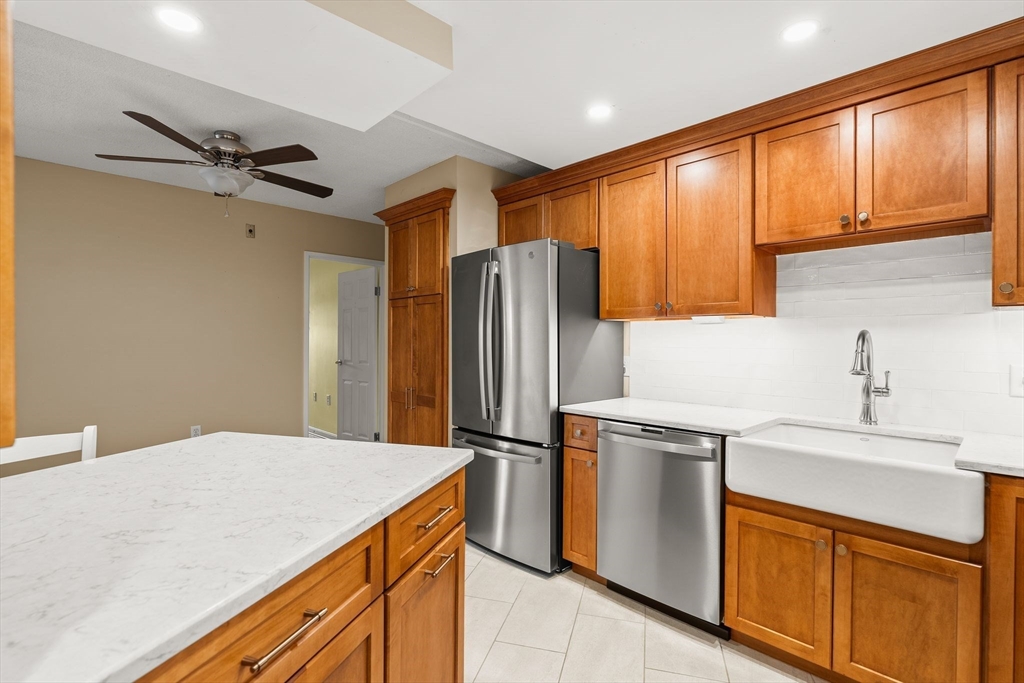 155 George Washington Boulevard, Unit 210 Hull, MA 02045 - Photo 11 of 42 a kitchen with a sink a refrigerator and cabinets