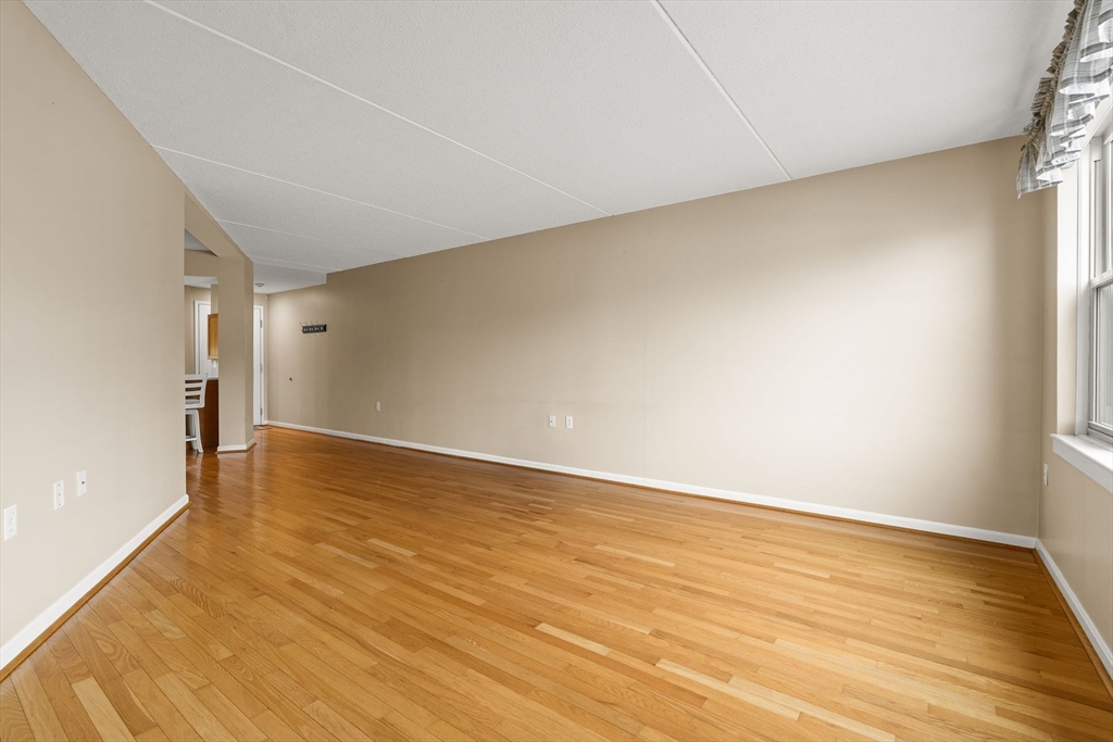 155 George Washington Boulevard, Unit 210 Hull, MA 02045 - Photo 17 of 42 a view of an empty room and wooden floor