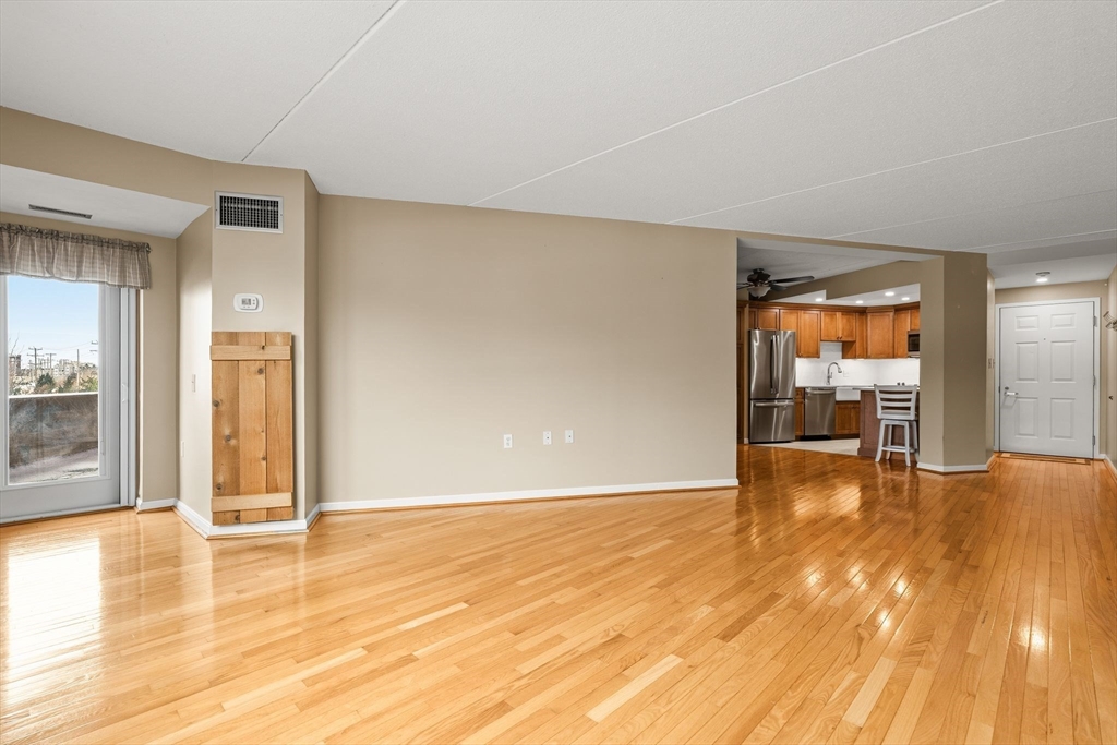 155 George Washington Boulevard, Unit 210 Hull, MA 02045 - Photo 18 of 42 a view of empty room with wooden floor and fireplace