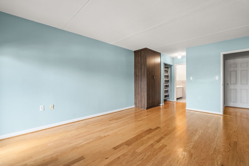 155 George Washington Boulevard, Unit 210 Hull, MA 02045 - Photo 23 of 42 a view of an empty room with wooden floor