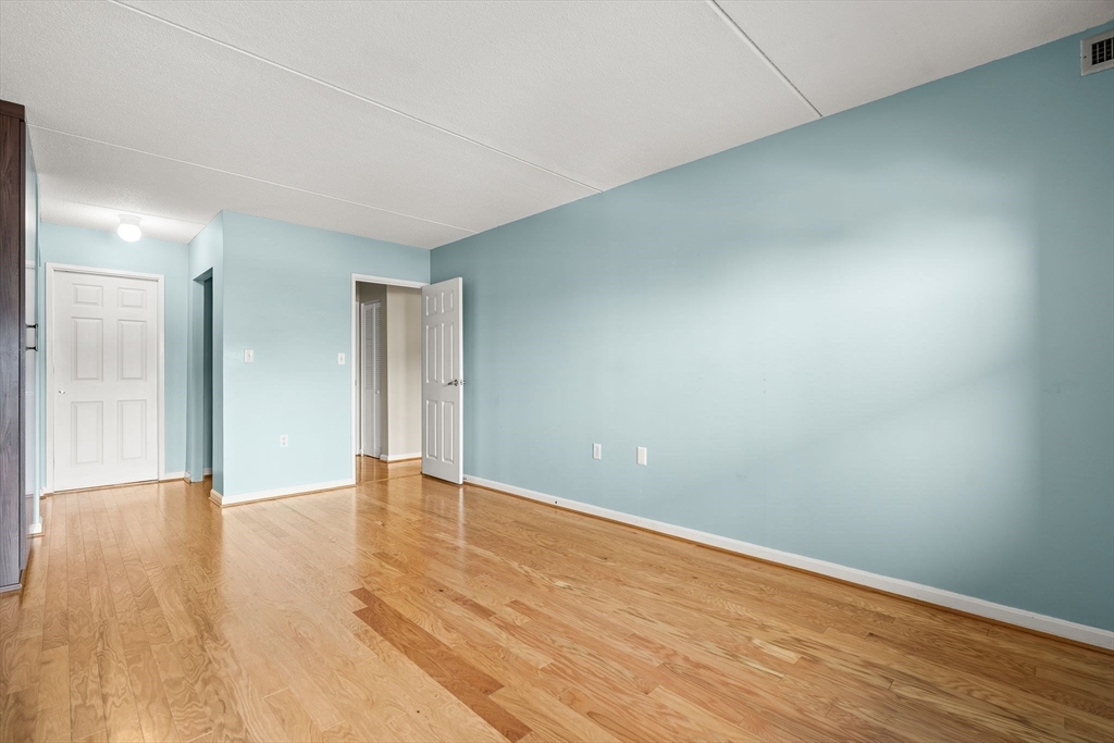 155 George Washington Boulevard, Unit 210 Hull, MA 02045 - Photo 24 of 42 a view of an empty room with wooden floor