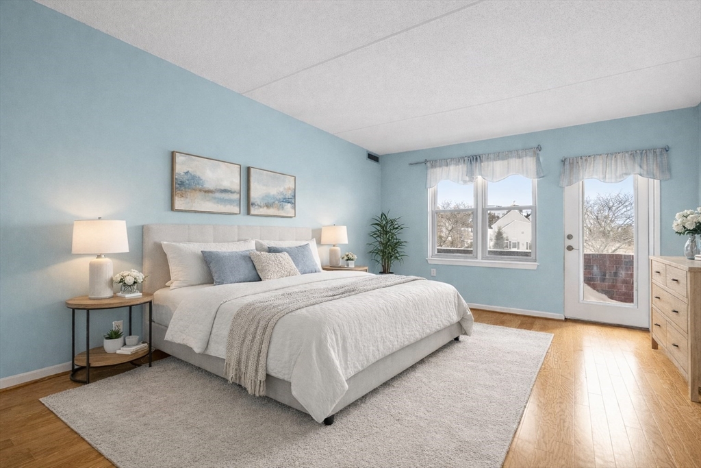 155 George Washington Boulevard, Unit 210 Hull, MA 02045 - Photo 25 of 42 a bedroom with a bed and a lamp on table