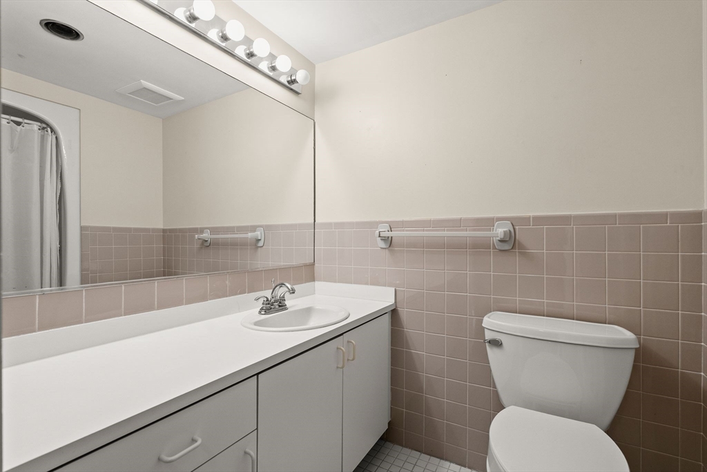 155 George Washington Boulevard, Unit 210 Hull, MA 02045 - Photo 30 of 42 a bathroom with a toilet sink and mirror