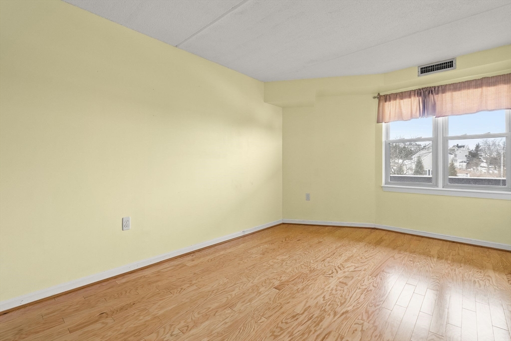 155 George Washington Boulevard, Unit 210 Hull, MA 02045 - Photo 33 of 42 a view of a room with wooden floor and window