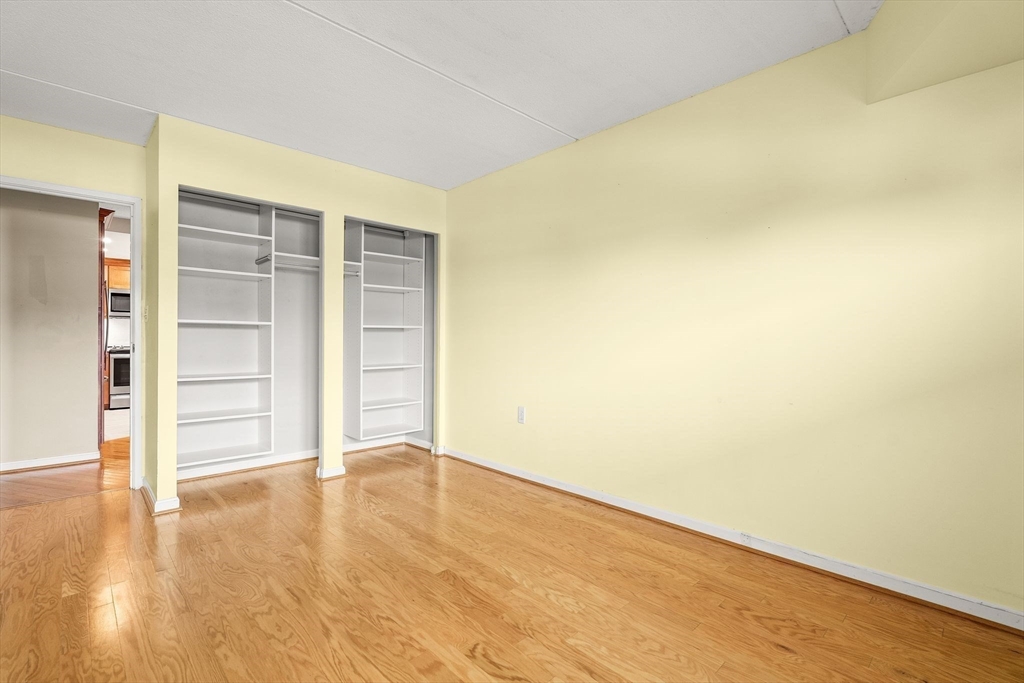 155 George Washington Boulevard, Unit 210 Hull, MA 02045 - Photo 35 of 42 an empty room with wooden floor and closet