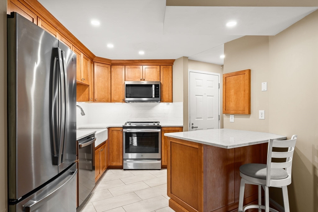 155 George Washington Boulevard, Unit 210 Hull, MA 02045 - Photo 7 of 42 a kitchen with stainless steel appliances granite countertop a refrigerator a stove top oven a sink dishwasher and white cabinets