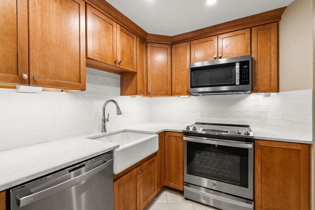 155 George Washington Boulevard, Unit 210 Hull, MA 02045 - Photo 8 of 42 a kitchen with granite countertop cabinets stainless steel appliances and a sink