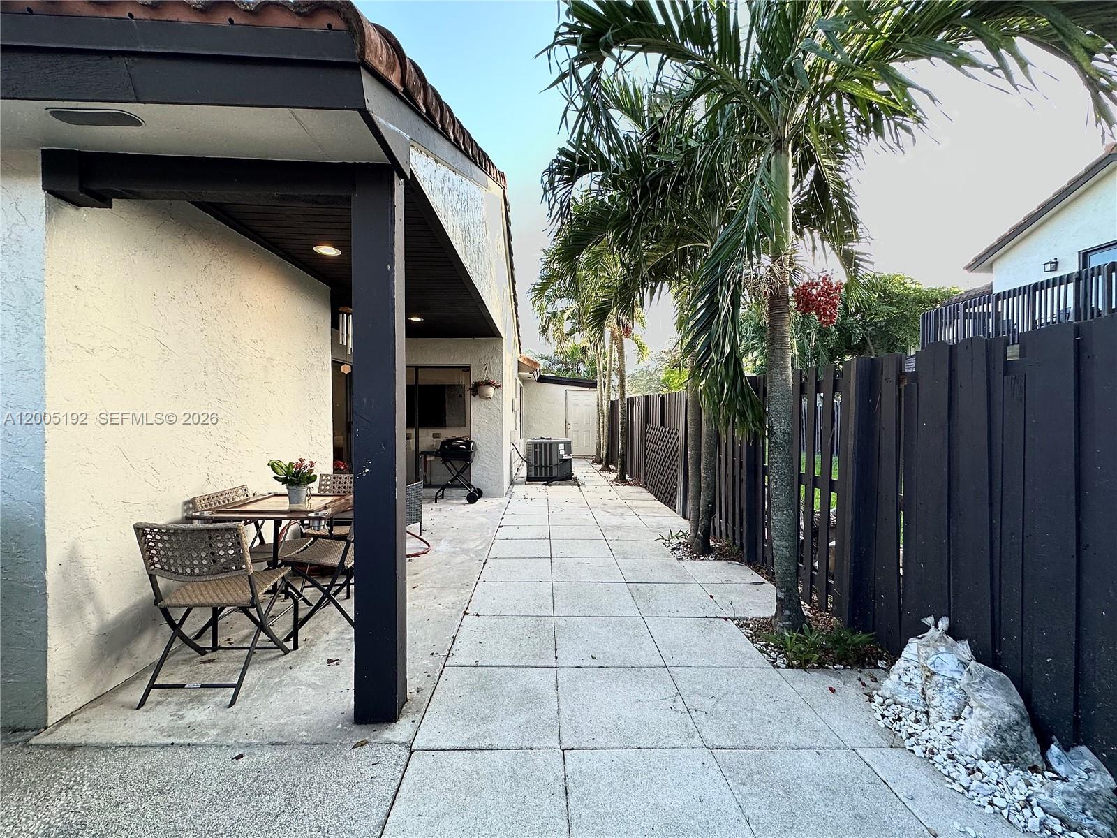 4840 Southwest 149th Court, Unit 16F Miami, FL 33185 - Photo 29 of 33 a backyard of a house with table and chairs