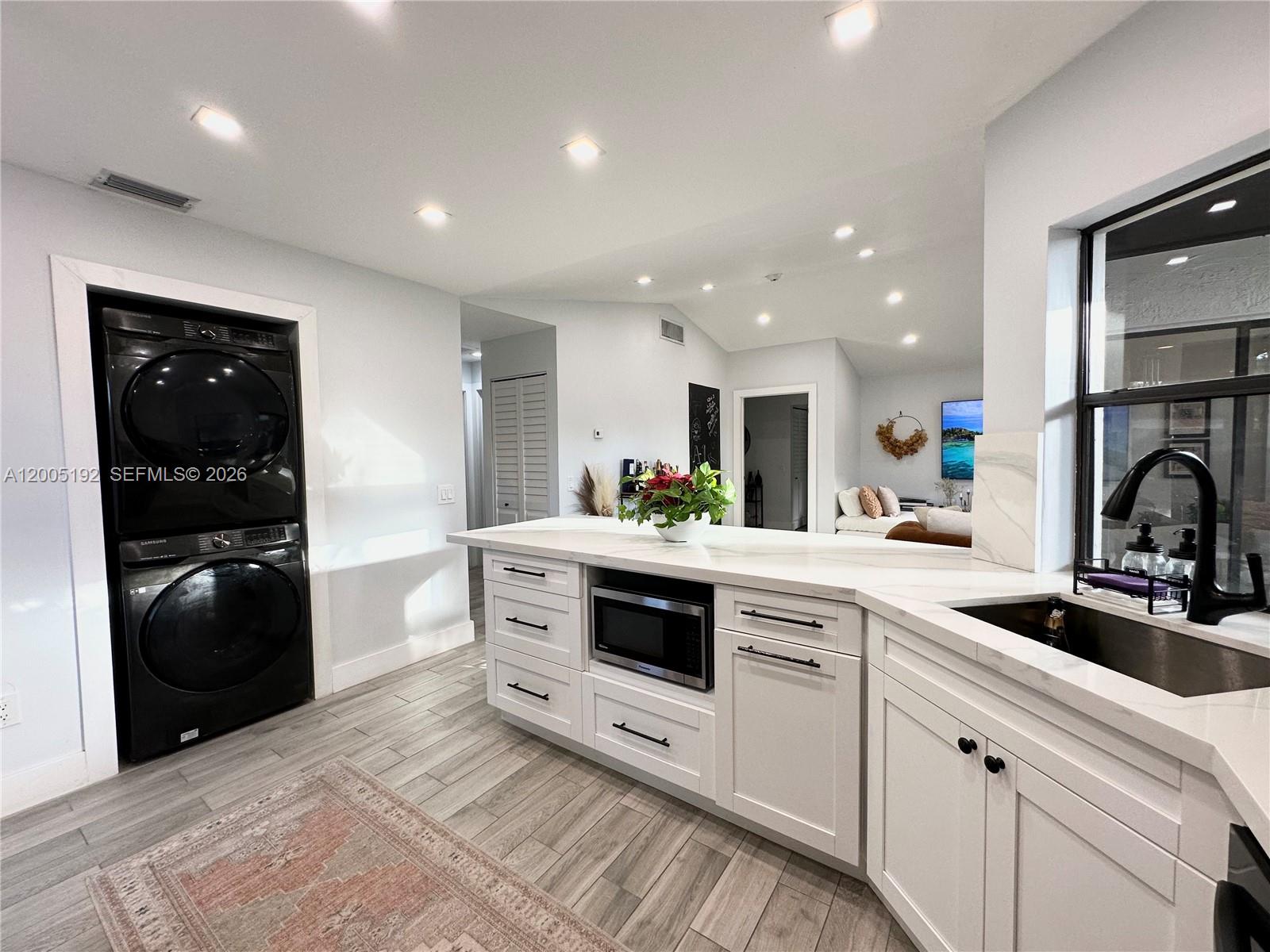 4840 Southwest 149th Court, Unit 16F Miami, FL 33185 - Photo 6 of 33 a kitchen with white cabinets and stainless steel appliances