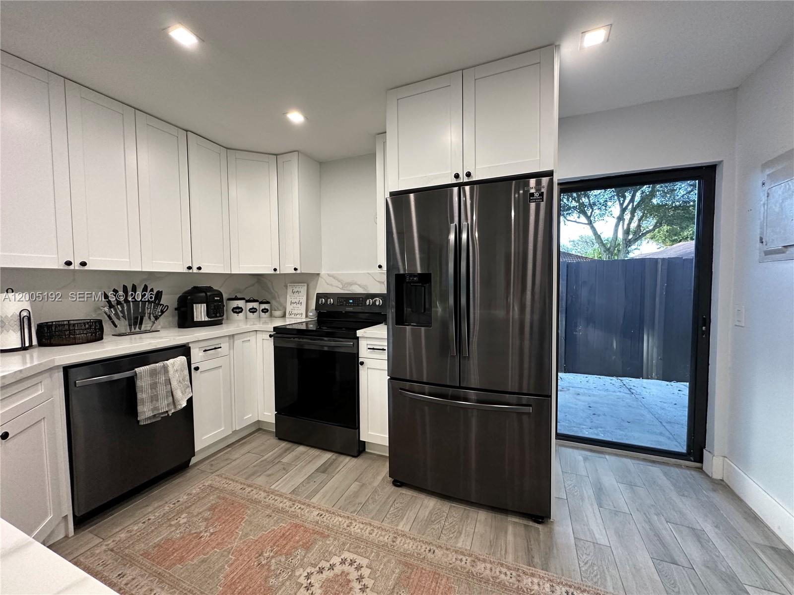 4840 Southwest 149th Court, Unit 16F Miami, FL 33185 - Photo 8 of 33 a kitchen with a refrigerator and a stove top oven