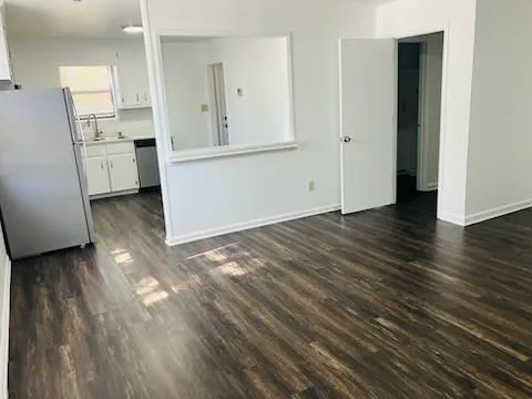 an empty room with wooden floor and cabinet