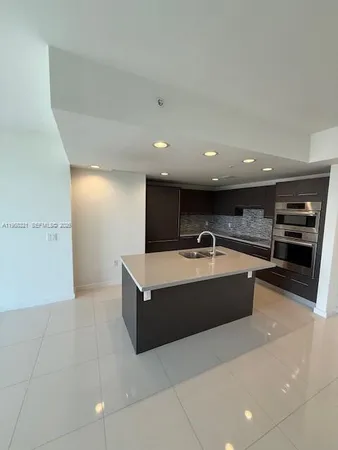 a large kitchen with stainless steel appliances a large counter top and a stove