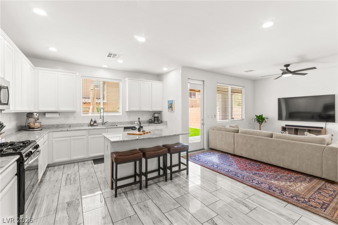 6435 Point Isabel Way Las Vegas, NV 89122 - Photo 13 of 57 A well-lit, open-concept kitchen and living area showcases an inviting atmosphere for daily living and entertaining.