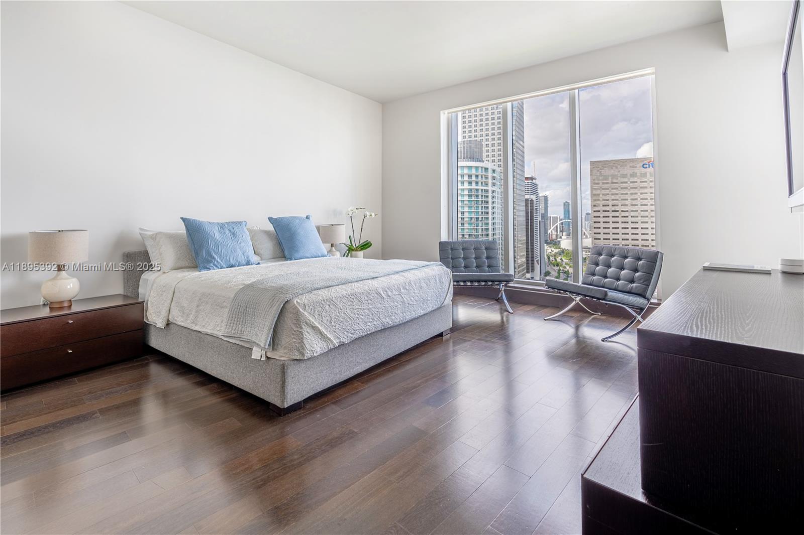 901 Brickell Key Boulevard, Unit 3607 Miami, FL 33131 - Photo 11 of 46 a bedroom with a bed and wooden floor