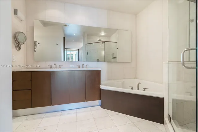 a bathroom with a tub sink and mirror