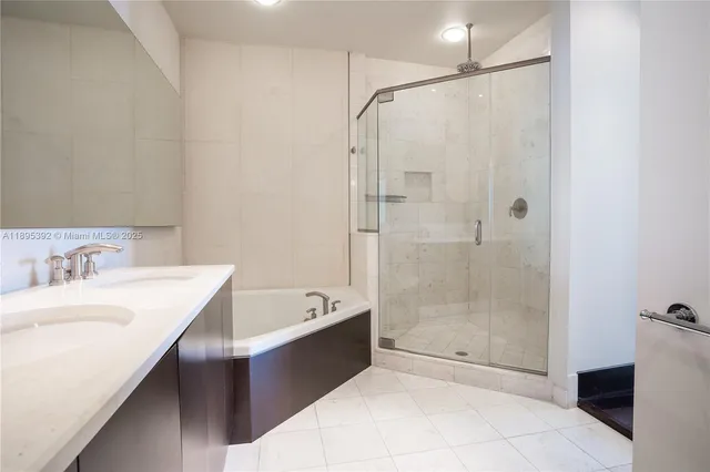 a bathroom with a tub sink shower and mirror