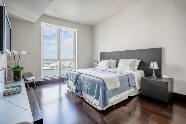 a bedroom with a bed and large windows