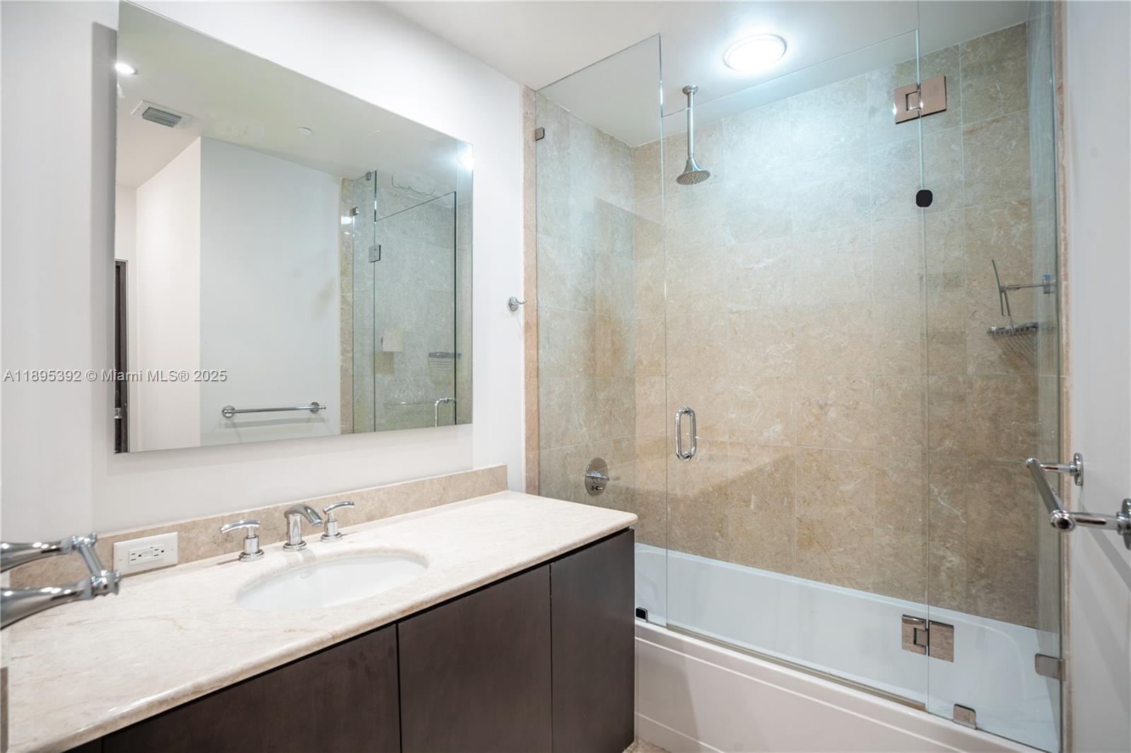901 Brickell Key Boulevard, Unit 3607 Miami, FL 33131 - Photo 25 of 46 a bathroom with a granite countertop sink toilet and shower