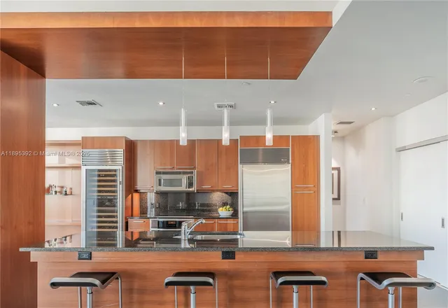 a kitchen with stainless steel appliances granite countertop a barbecue grill and cabinets