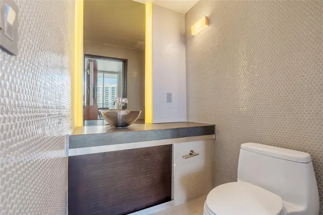 a bathroom with a granite countertop toilet sink and mirror