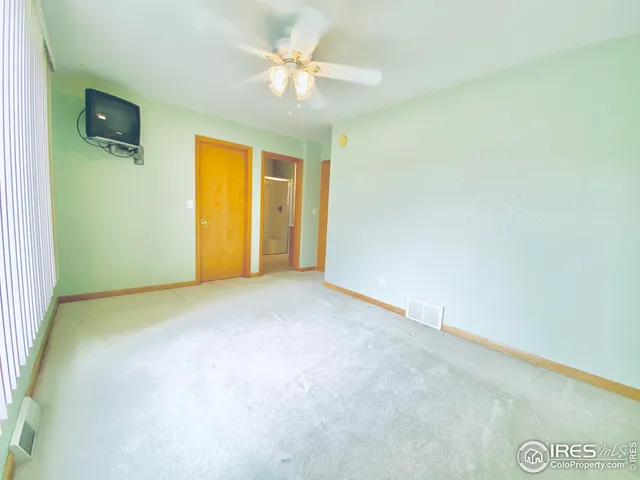 an empty room with a chandelier fan and a ceiling fan