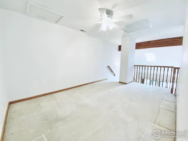 an empty room with a ceiling fan and a window