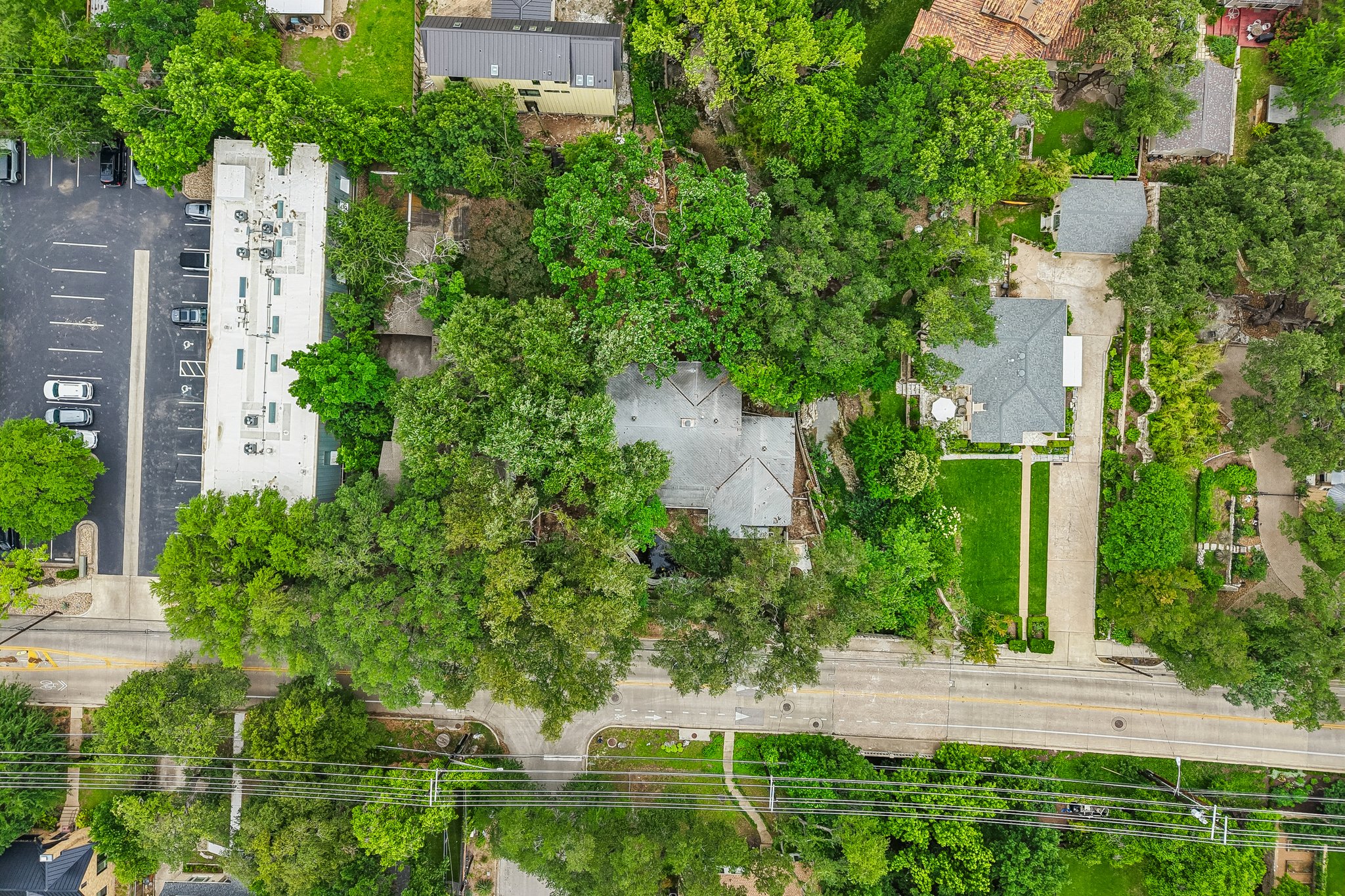 801 East 32nd Street Austin, TX 78705 - Photo 4 of 13 An aerial perspective reveals a private residence nestled amidst verdant mature trees and lush landscaping.