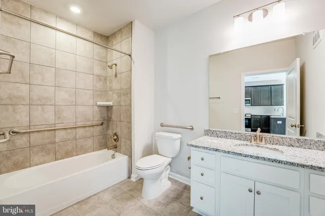 a bathroom with a granite countertop sink a toilet and bathtub