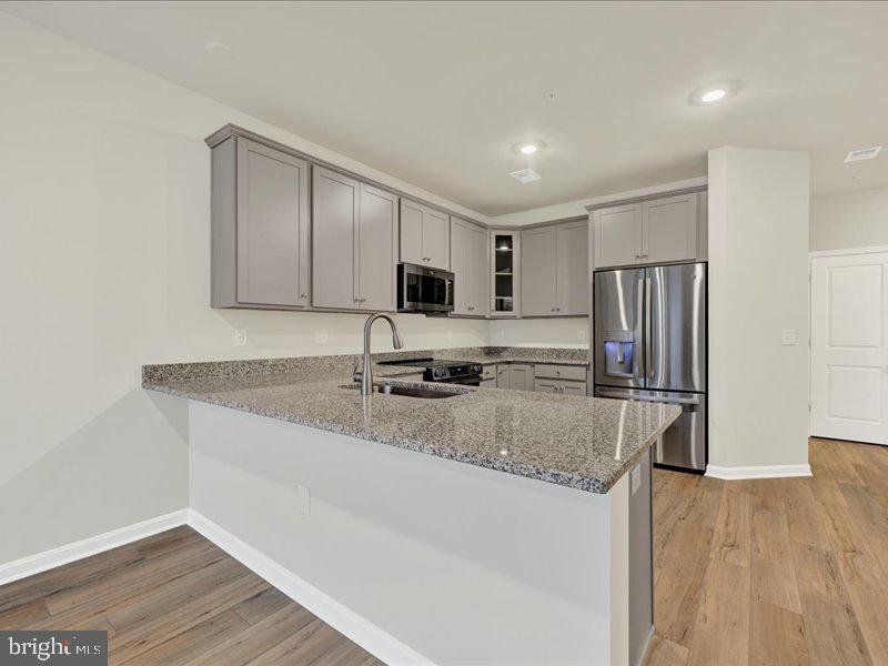 4003 Seaside Alder Road, Unit 102 ASTER Bowie, MD 20720 - Photo 15 of 27 a kitchen with stainless steel appliances granite countertop a sink refrigerator and microwave
