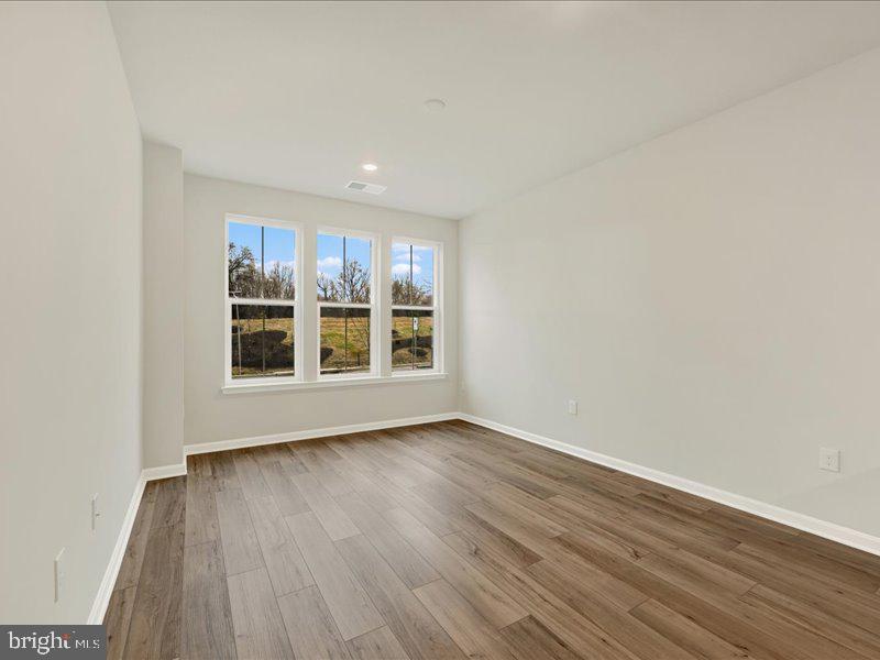 4003 Seaside Alder Road, Unit 102 ASTER Bowie, MD 20720 - Photo 17 of 27 an empty room with wooden floor and window