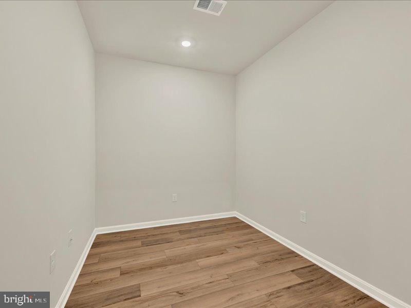 4003 Seaside Alder Road, Unit 102 ASTER Bowie, MD 20720 - Photo 19 of 27 a view of a room with wooden floor and white walls
