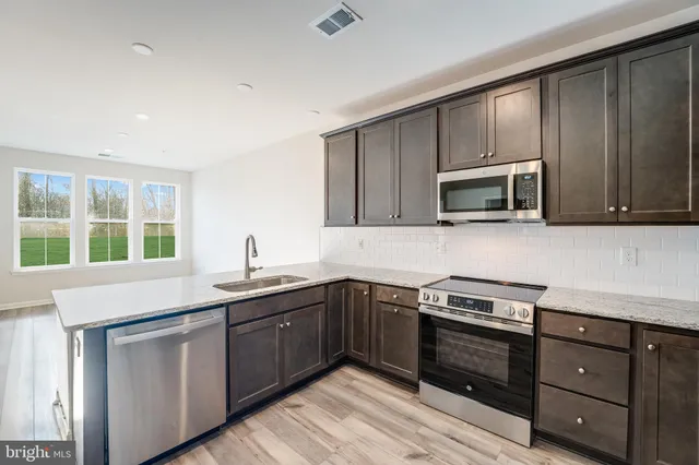 a kitchen with a sink stove and microwave