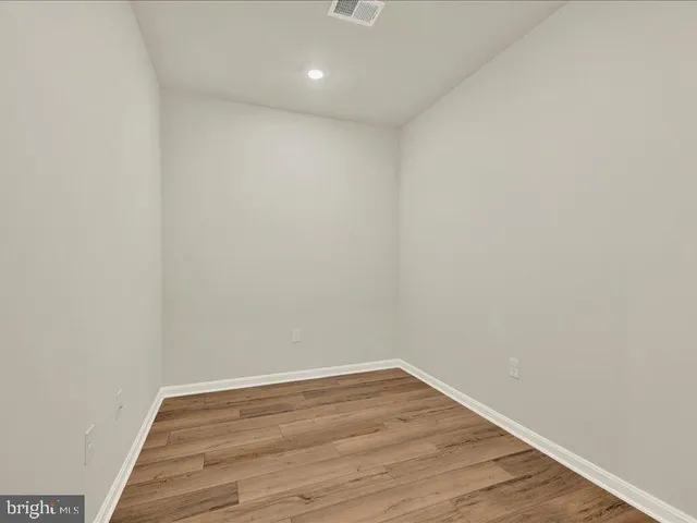 a view of a room with wooden floor and white walls