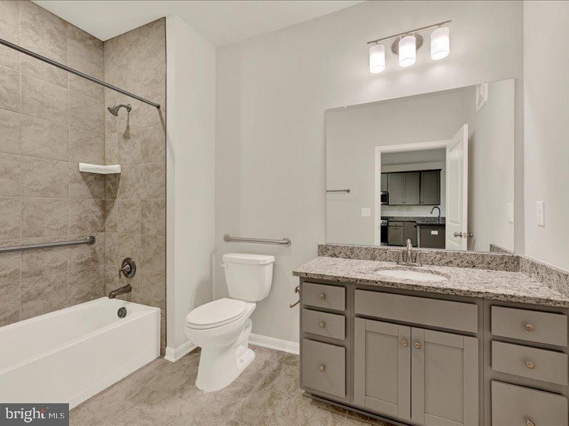 4003 Seaside Alder Road, Unit 102 ASTER Bowie, MD 20720 - Photo 23 of 27 a bathroom with a granite countertop sink a toilet and bathtub