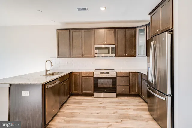 a kitchen with stainless steel appliances granite countertop a refrigerator and a sink