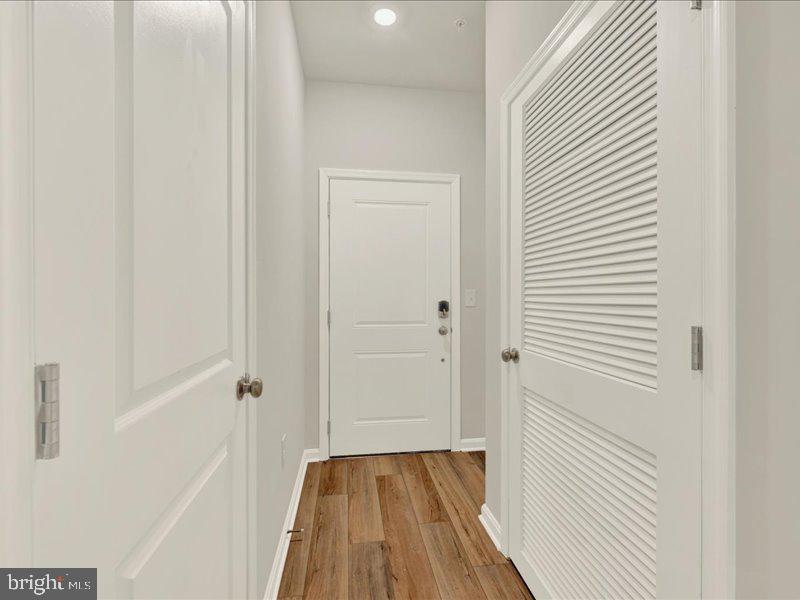 4003 Seaside Alder Road, Unit 102 ASTER Bowie, MD 20720 - Photo 3 of 27 a view of a hallway with wooden floor and a bathroom